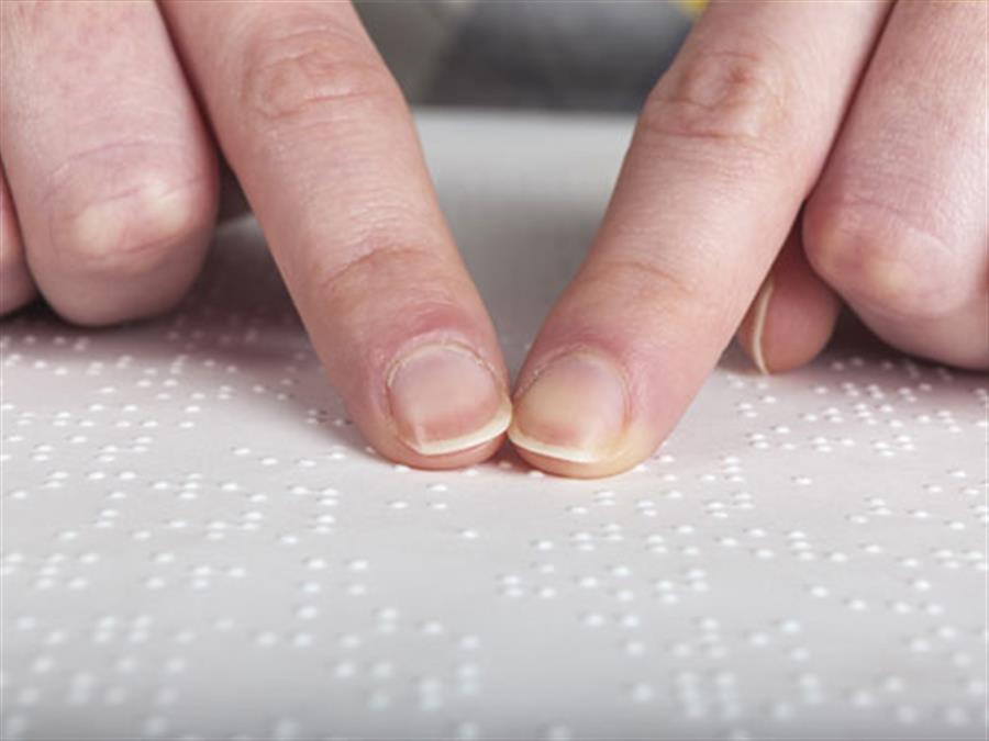 Fingers reading braille.